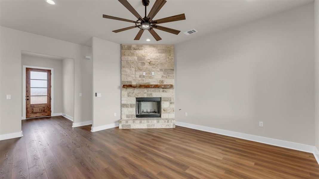 Rich wood floors meet a floor-to-ceiling stone fireplace in this open living area. Rich wood floors meet a floor-to-ceiling stone fireplace in this open living area.