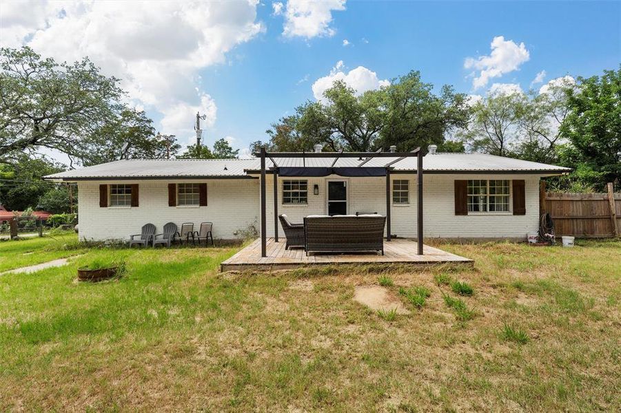 Back of house featuring a wooden deck, metal roof, brick siding, and outdoor lounge area Back of house featuring a wooden deck, metal roof, brick siding, and outdoor lounge area