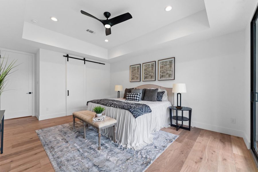 Sleek modern barn doors lead to the spa-worthy bath and boutique-inspired closet.