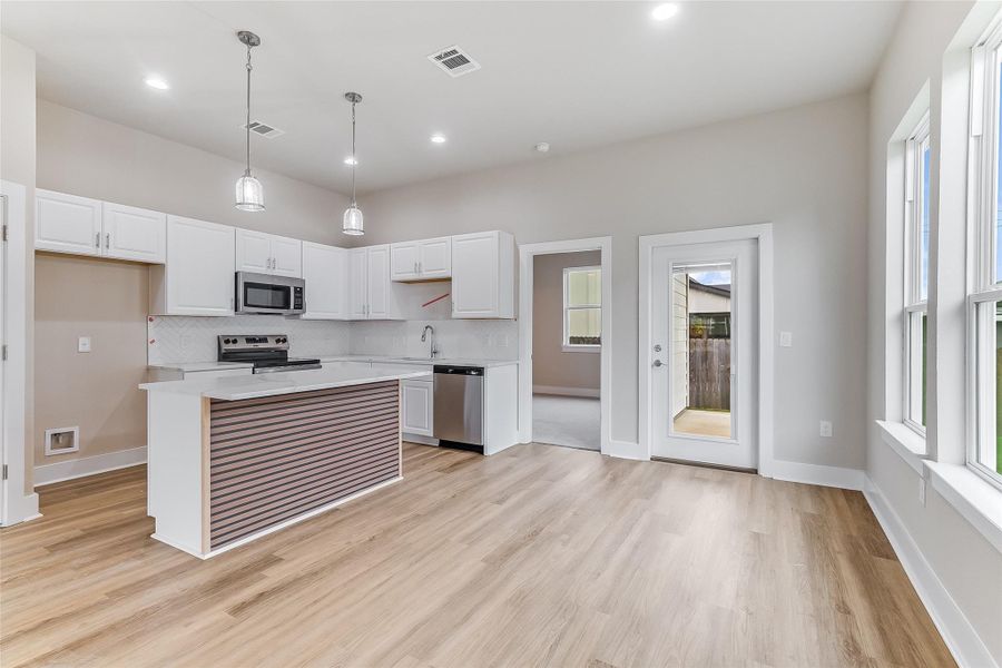 Kitchen featuring stainless steel appliances, light countertops, plenty of natural light, tasteful backsplash, and recessed lighting