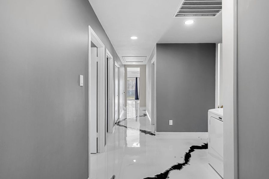 Hallway with recessed lighting and washer / dryer