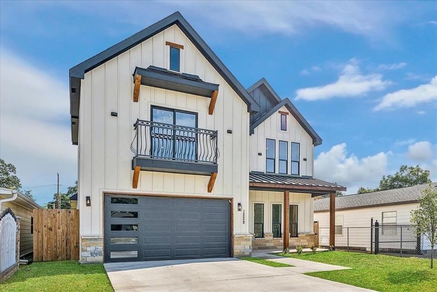 Modern inspired farmhouse with board and batten siding, a standing seam roof, an attached garage, a metal roof, and concrete driveway