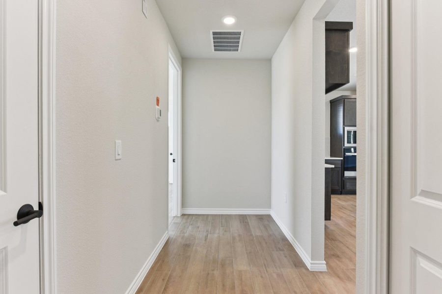 Hallway featuring light wood-style flooring and baseboards