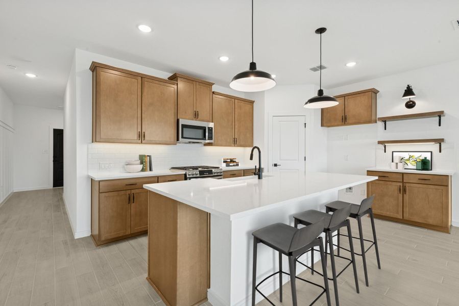 Stunning kitchen with light stain cabinets and quartz counters (*Photo not of actual home and used for illustration purposes only.)