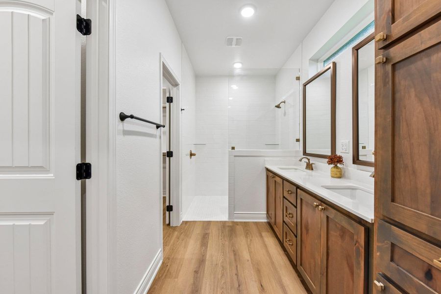 Refined wood-tone cabinetry provides ample storage in this well-appointed bath. Refined wood-tone cabinetry provides ample storage in this well-appointed bath.