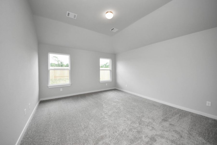 Escape to tranquility in this spacious primary room, adorned with plush carpeting and bathed in the soothing hues of warm paint colors, creating a cozy retreat for relaxation. Sample photo of completed home with similar floor plan. Actual colors and selections may vary. Escape to tranquility in this spacious primary room, adorned with plush carpeting and bathed in the soothing hues of warm paint colors, creating a cozy retreat for relaxation. Sample photo of completed home with similar floor plan. Actual colors and selections may vary.