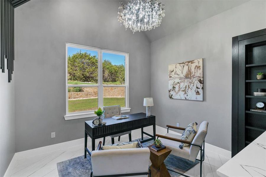 Home office with vaulted ceiling and an inviting chandelier