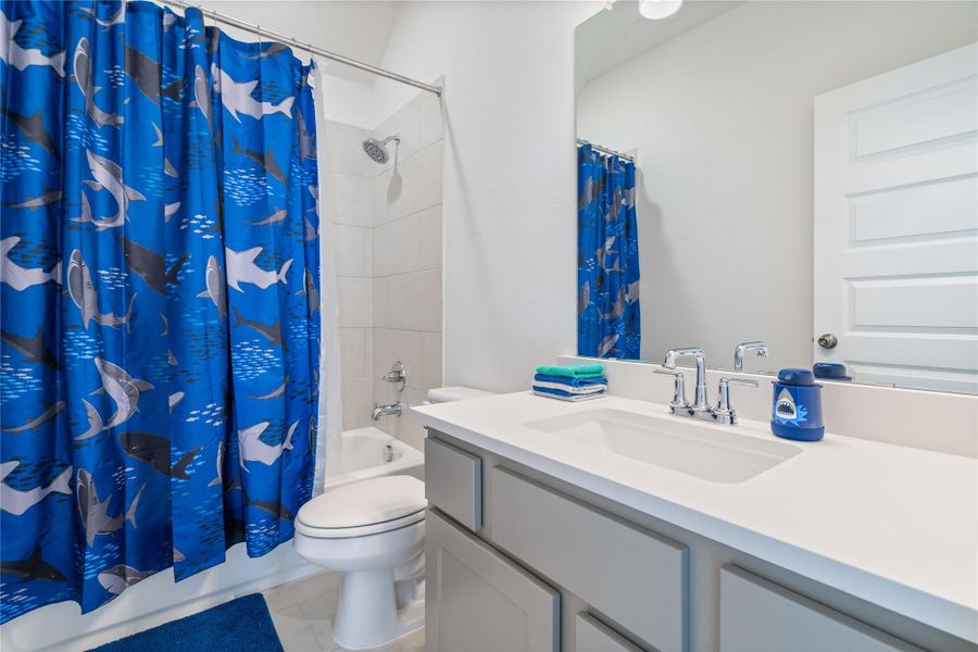 This full bathroom includes a bathtub/shower combo and tile flooring throughout.