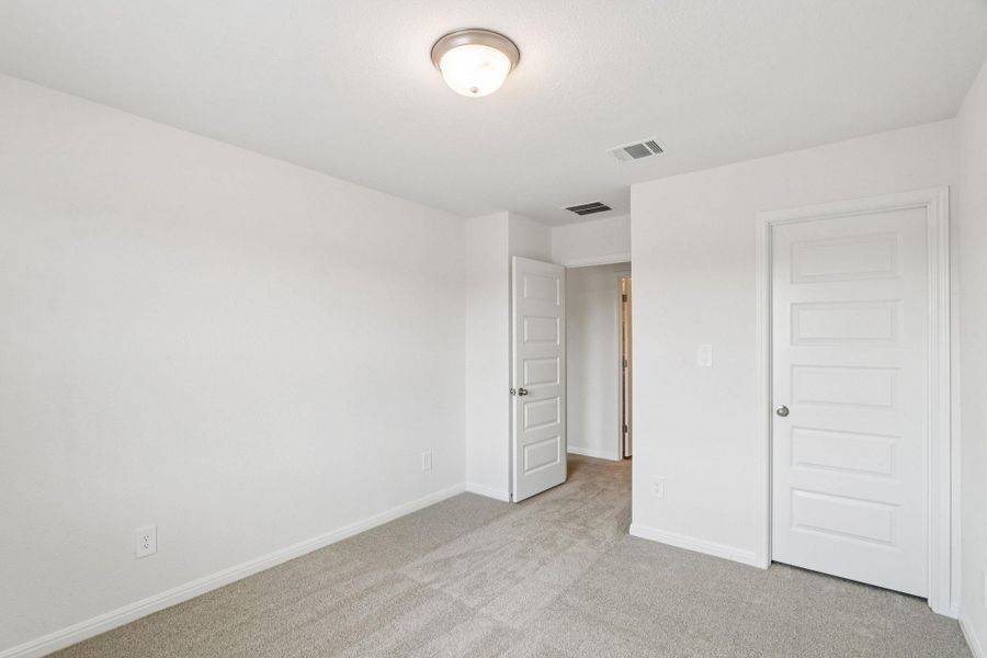 Unfurnished bedroom with light carpet and baseboards Unfurnished bedroom with light carpet and baseboards