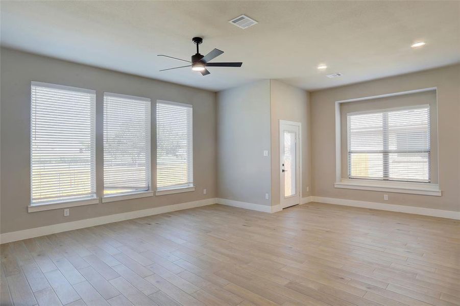 Unfurnished living room featuring a ceiling fan, light wood-type flooring, and recessed lighting
