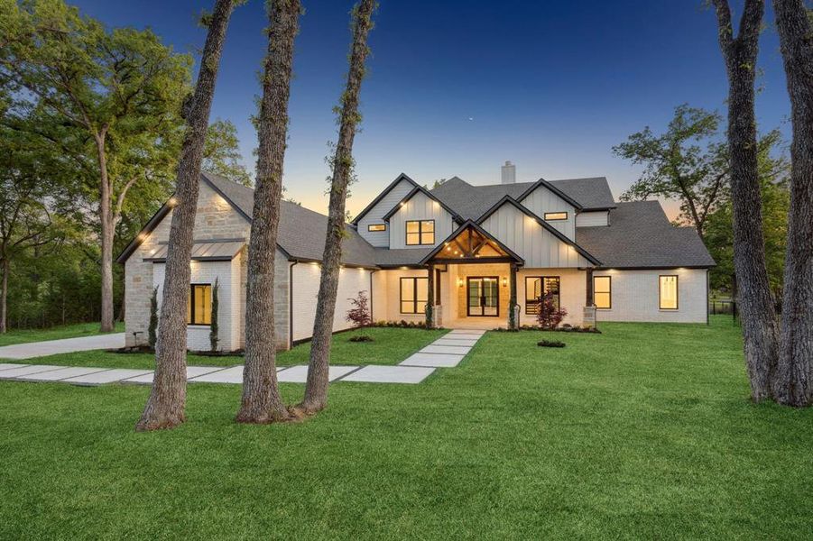 Modern inspired farmhouse featuring a lawn, roof with shingles, board and batten siding, and a chimney Modern inspired farmhouse featuring a lawn, roof with shingles, board and batten siding, and a chimney