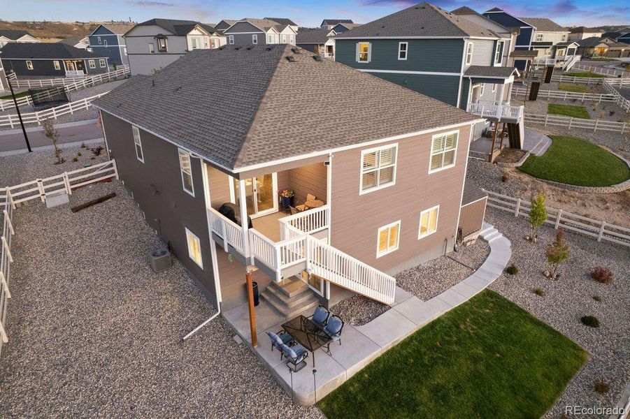 Aerial view of the covered deck, walkout patio, and low-maintenance landscaping.
