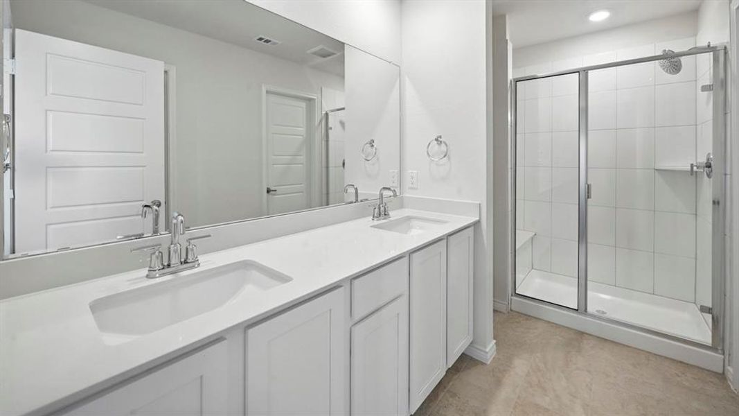 Bathroom featuring a dual vanity with integrated sinks and chrome fixtures, extensive wall mirror, and a glass-enclosed shower with a built-in bench and shelf Bathroom featuring a dual vanity with integrated sinks and chrome fixtures, extensive wall mirror, and a glass-enclosed shower with a built-in bench and shelf