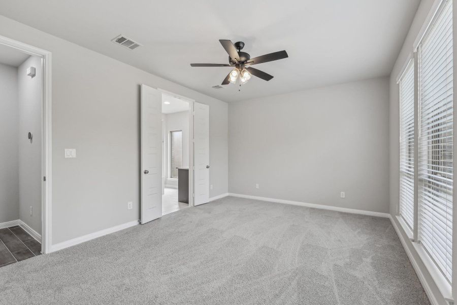 Unfurnished bedroom with carpet floors, baseboards, and ensuite bathroom Unfurnished bedroom with carpet floors, baseboards, and ensuite bathroom