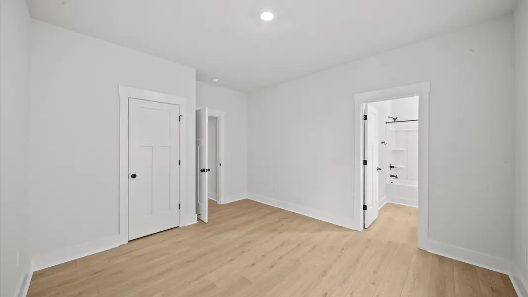 Thoughtfully designed secondary bedrooms featuring hardwood flooring and tasteful detail