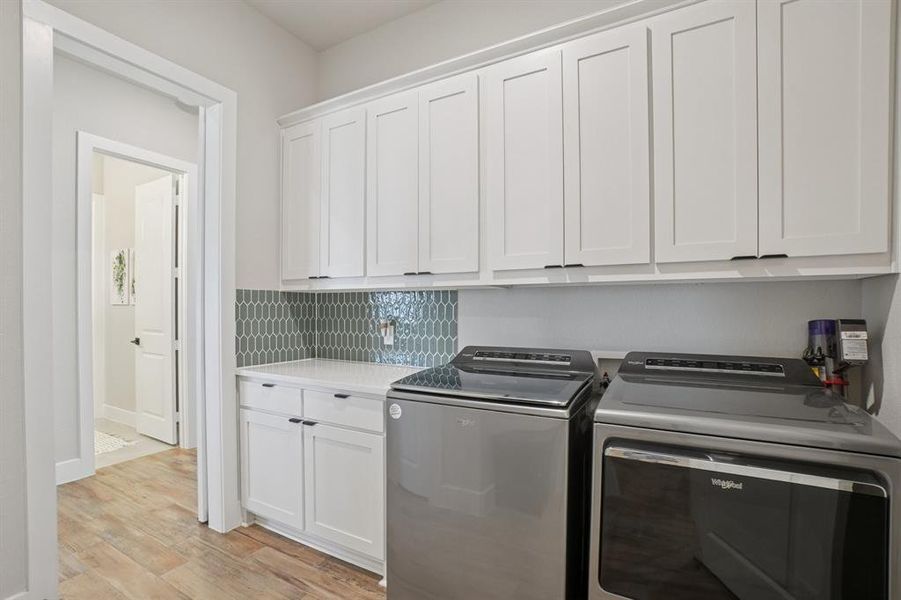 Washroom has plenty of cabinets for storage, linen closet, and room for full size washer and dryer.