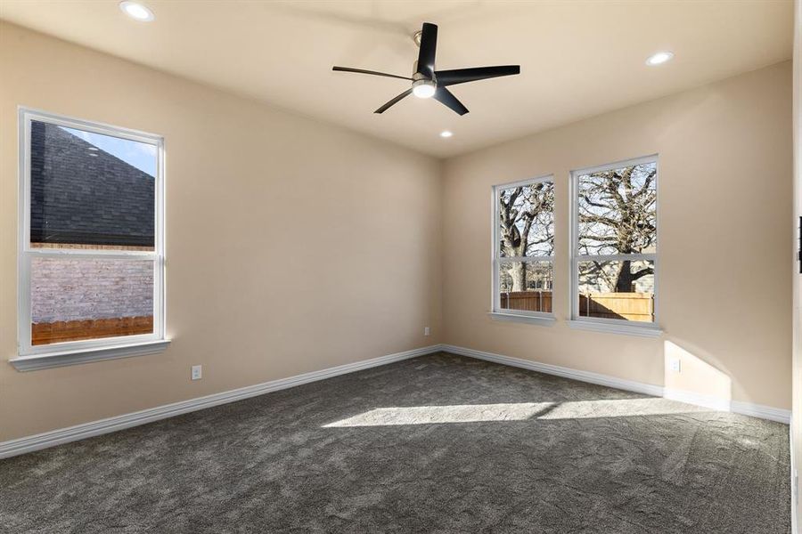 Spare room with dark colored carpet and ceiling fan