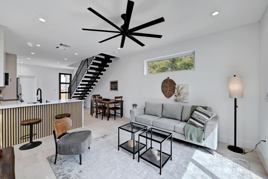 Living area with recessed lighting, stairway, plenty of natural light, and ceiling fan