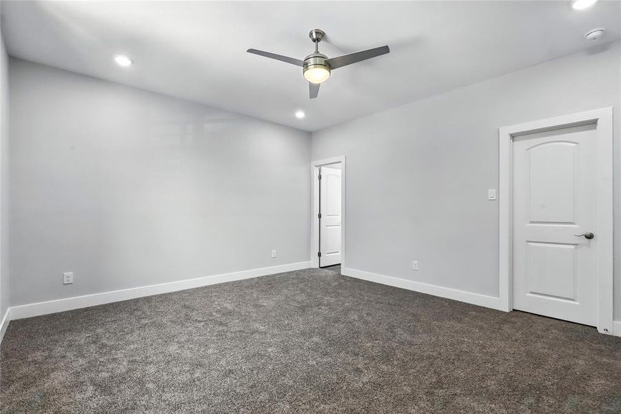 Unfurnished bedroom featuring dark carpet, recessed lighting, and ceiling fan