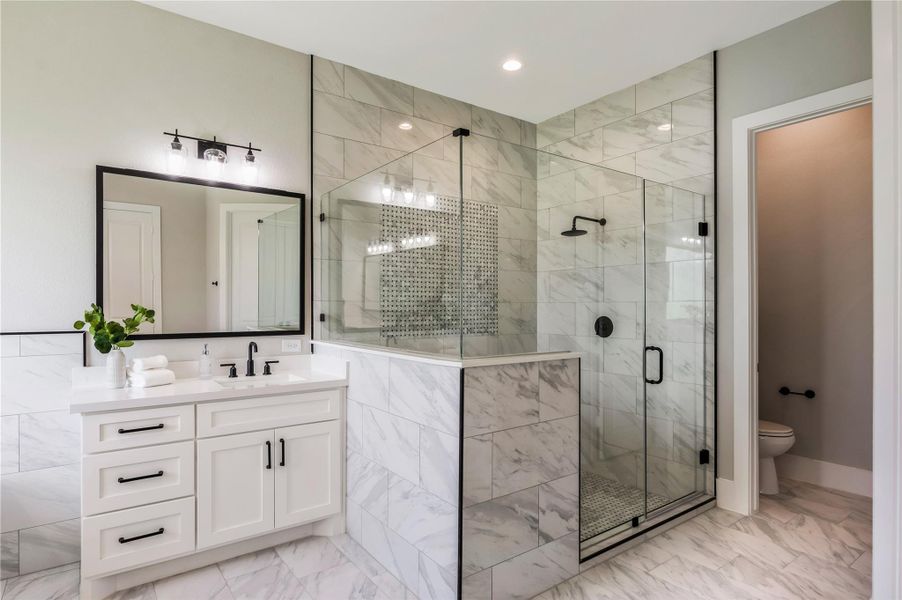 Indulge in the luxurious oversized walk-in shower, featuring exquisite custom tile work.