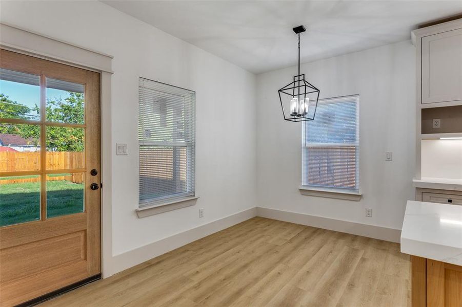 Unfurnished dining area with healthy amount of natural light, light wood-style floors, and a chandelier Unfurnished dining area with healthy amount of natural light, light wood-style floors, and a chandelier