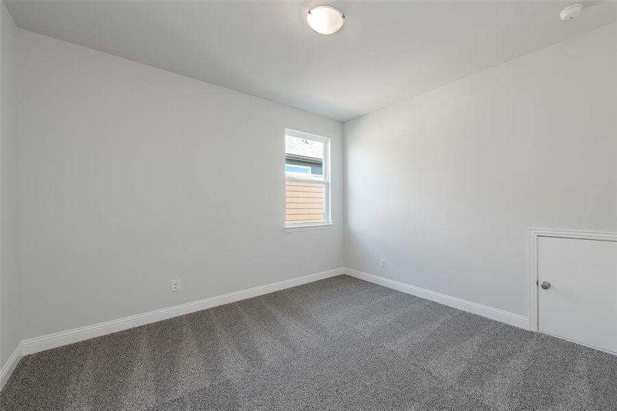 Spare room featuring carpet flooring, a smoke detector, and baseboards Spare room featuring carpet flooring, a smoke detector, and baseboards