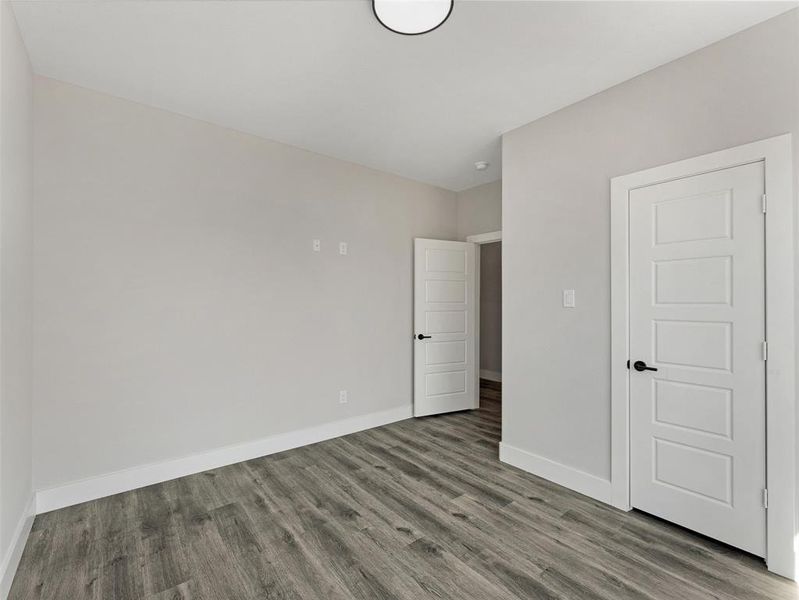 Unfurnished bedroom with hardwood / wood-style flooring