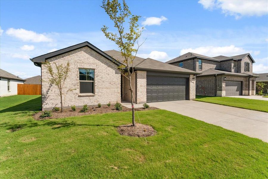 View of front facade featuring a front lawn and a garage