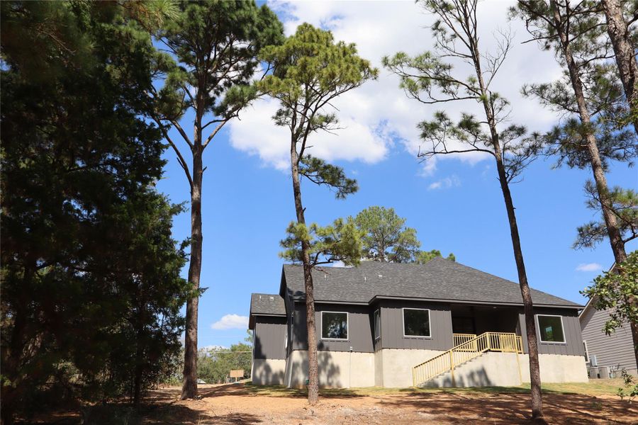 View of front of property featuring roof with shingles and stairs