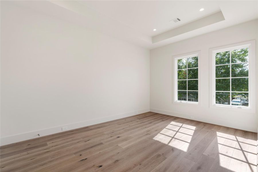 The second secondary bedroom features a twin set of front-facing windows and a tray ceiling. Lengthy walls are great for artwork and personalizing the room. A queen bed and additional bedroom furniture fit easily here.