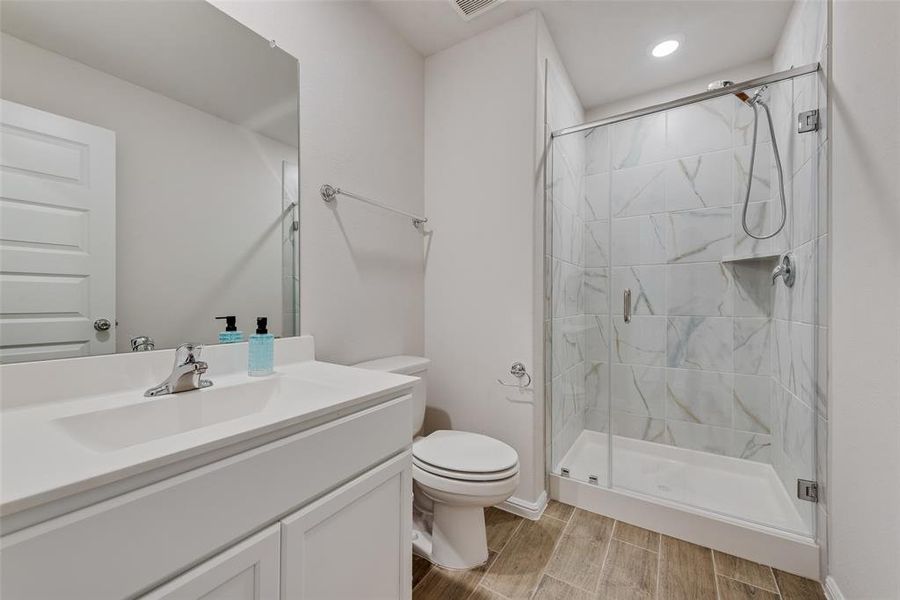 Full bath with wood tiled floors, a shower stall, and vanity Full bath with wood tiled floors, a shower stall, and vanity