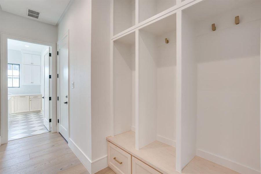 Mudroom with light wood-type flooring and baseboards