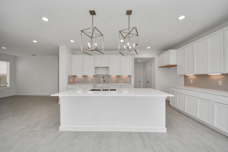 This kitchen is truly a chef's dream! This haven Boasts high ceilings, recessed & pendant lighting, stained wood cabinets, granite countertops, stainless steel appliances, a modern tile backsplash.  All of this overlooks your expansive family room, creating a perfect space for culinary delights and family gatherings.