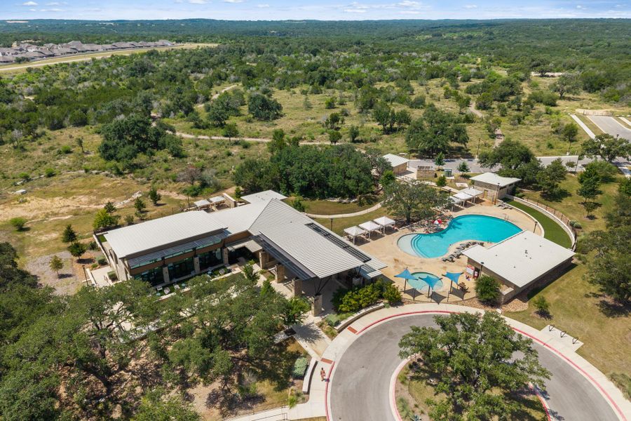 An aerial perspective showcases the community clubhouse and aquatic amenities set amidst a verdant landscape. An aerial perspective showcases the community clubhouse and aquatic amenities set amidst a verdant landscape.