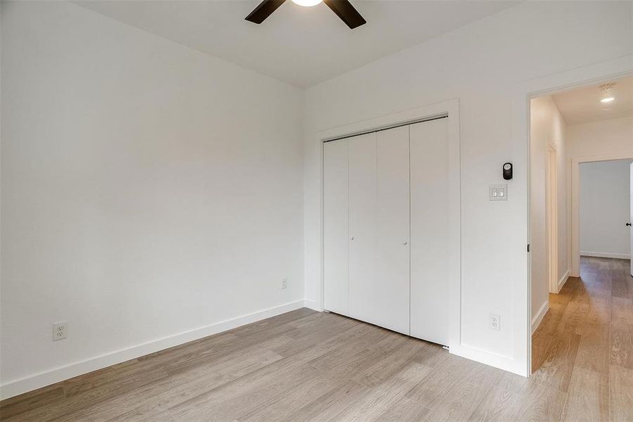 Unfurnished bedroom featuring light wood-style floors, baseboards, a closet, and ceiling fan Unfurnished bedroom featuring light wood-style floors, baseboards, a closet, and ceiling fan