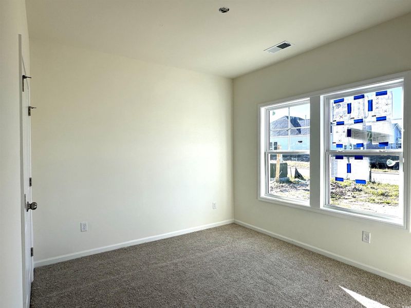 Carpeted empty room featuring baseboards
