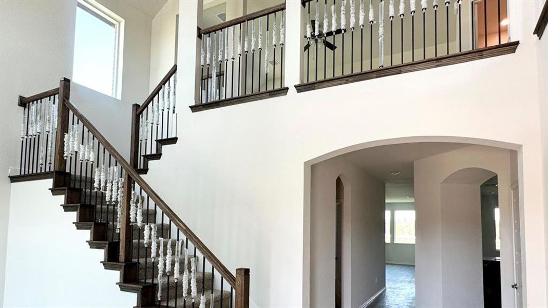 Staircase featuring a high ceiling and arched walkways Staircase featuring a high ceiling and arched walkways