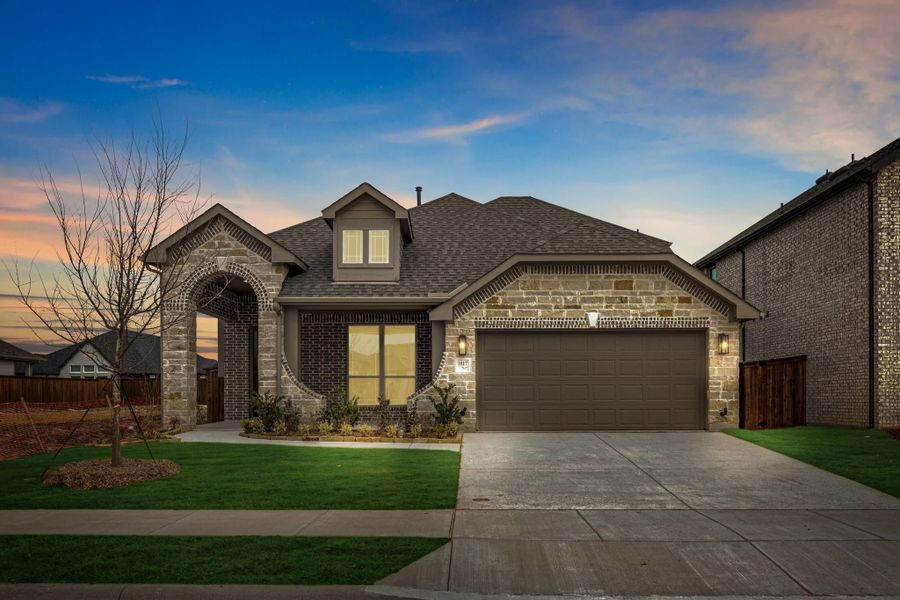 Single-story home with stone and brick exterior, arched entryway, two-car garage, and green front lawn. Single-story home with stone and brick exterior, arched entryway, two-car garage, and green front lawn.