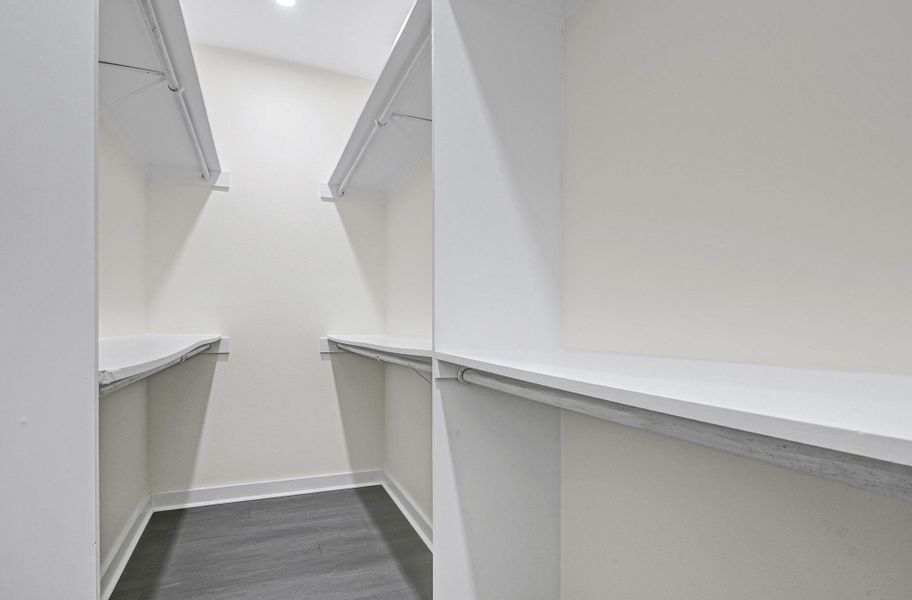 Spacious walk-in closet with ample shelving and storage. Spacious walk-in closet with ample shelving and storage.