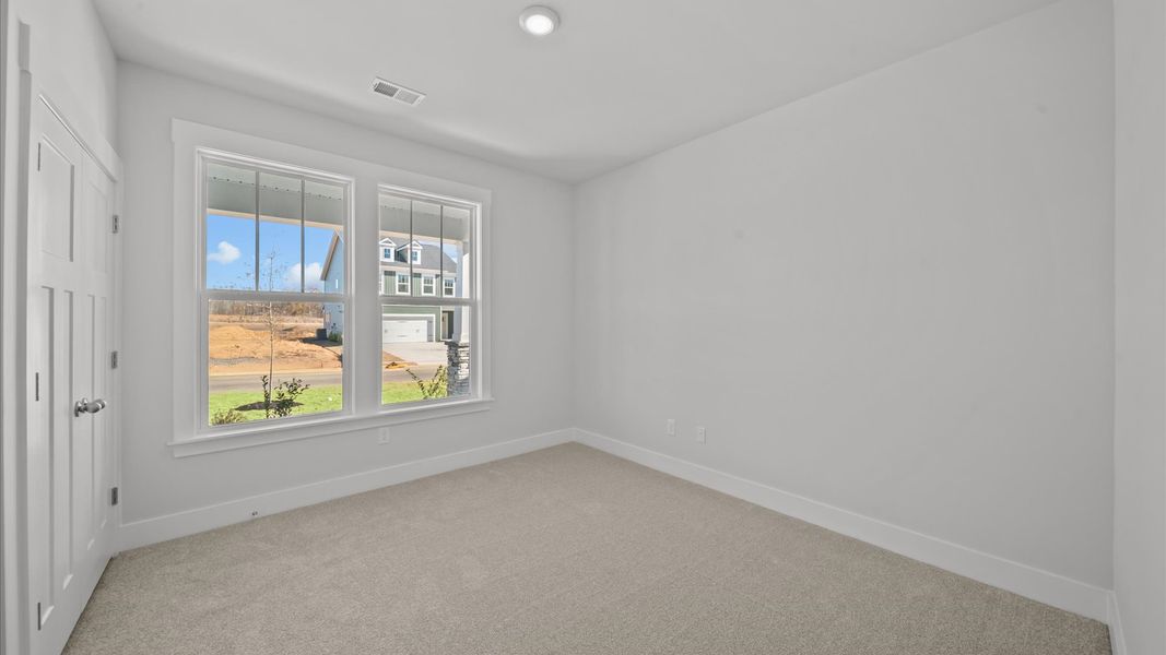 Superior comfort in this light-filled bedroom with plush carpeting and thoughtfully placed large windows