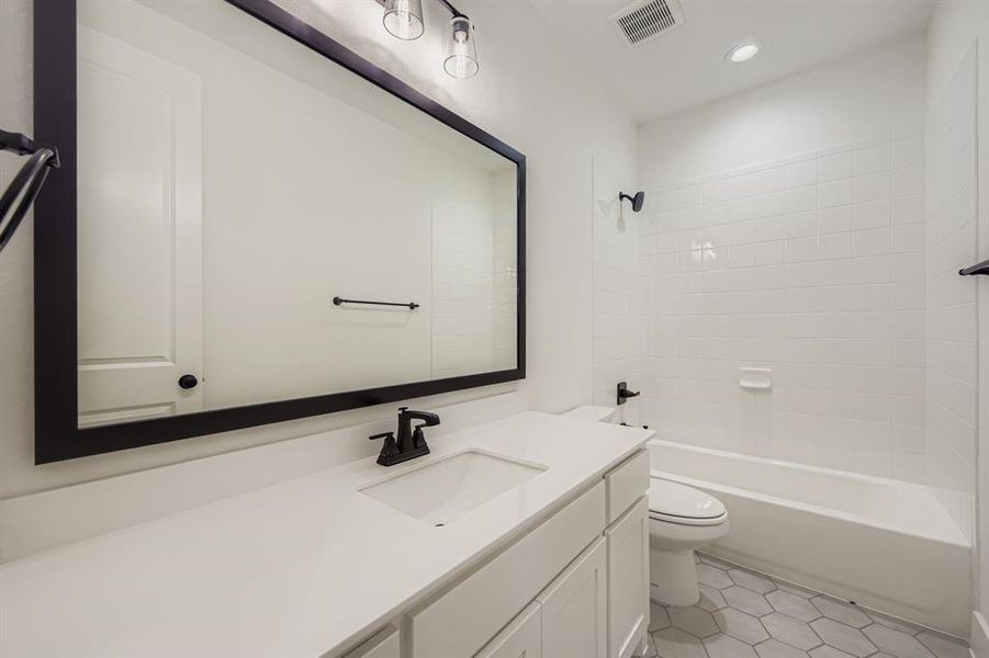 Bathroom featuring vanity,  shower combination, light tile patterned floors, and recessed lighting