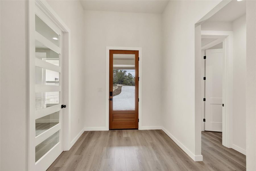 Foyer featuring light wood finished floors and baseboards
