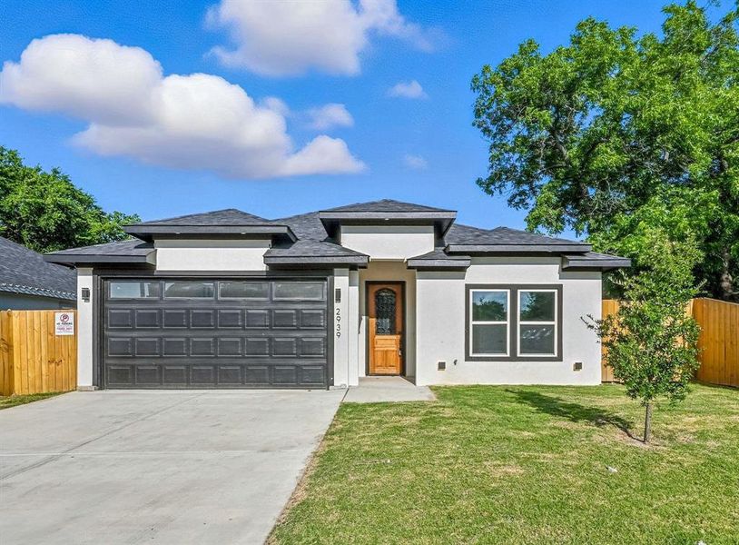 Prairie-style house featuring driveway, stucco siding, and a garage Prairie-style house featuring driveway, stucco siding, and a garage