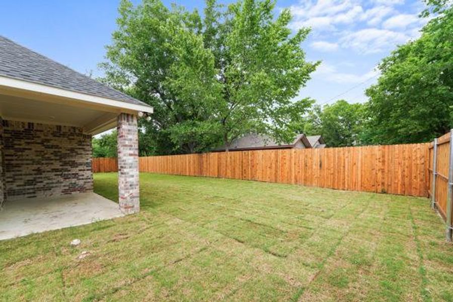 Expansive backyard featuring a newly laid sod lawn and a full privacy fence Expansive backyard featuring a newly laid sod lawn and a full privacy fence