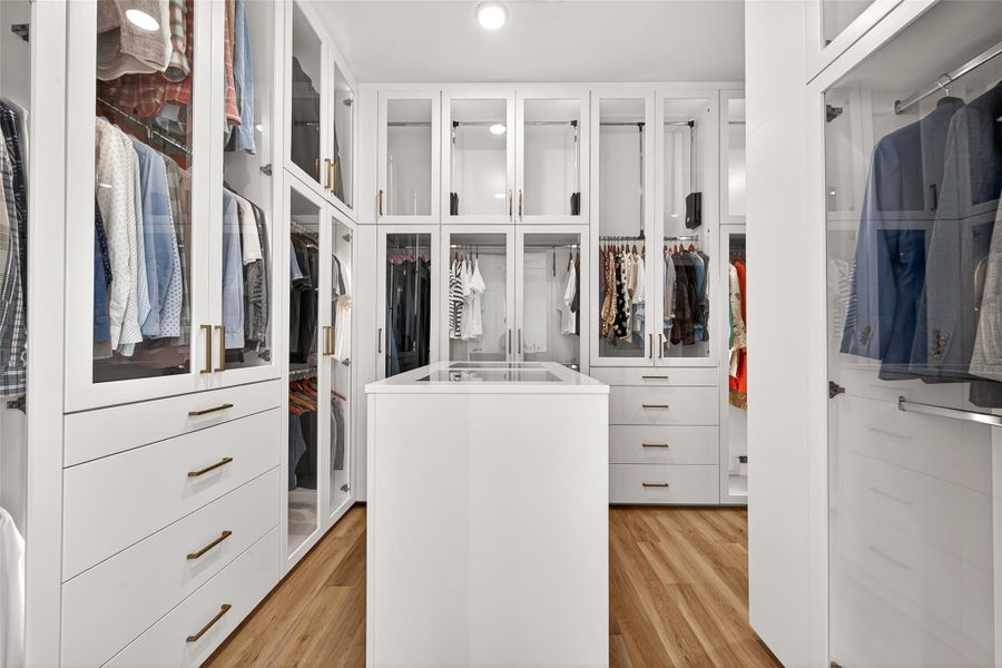 The custom-designed primary closet offers extensive built-in storage and display space for wardrobe essentials.