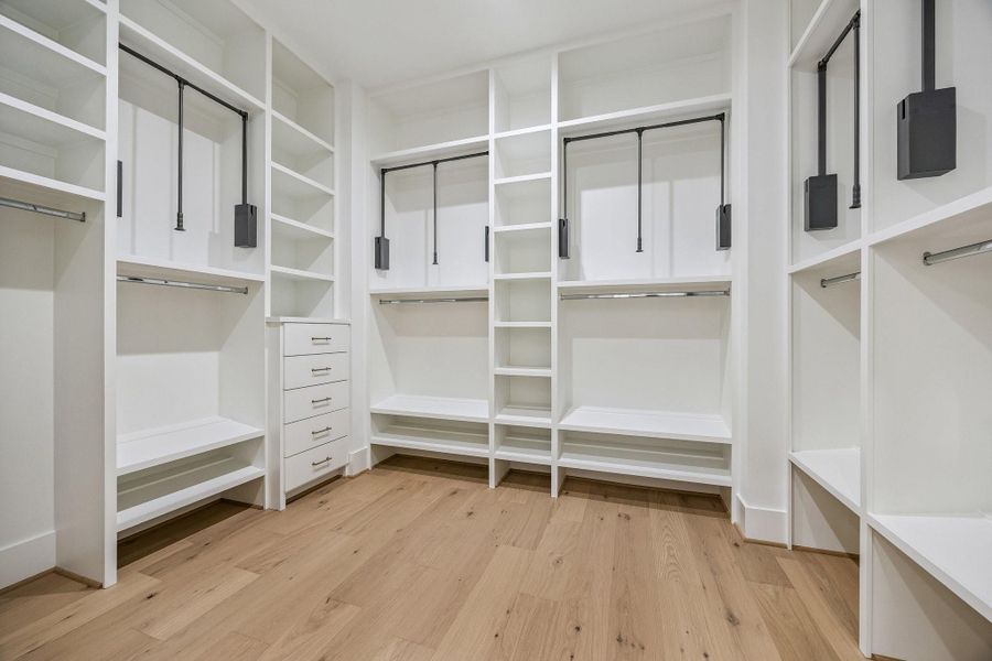Partial view of the Primary Closet with built-in dresser drawers, pulldowns, chrome rods and more. Partial view of the Primary Closet with built-in dresser drawers, pulldowns, chrome rods and more.