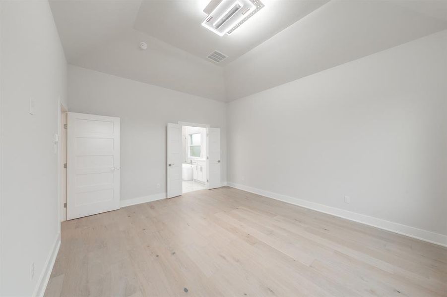 Unfurnished bedroom with light wood-type flooring and connected bathroom