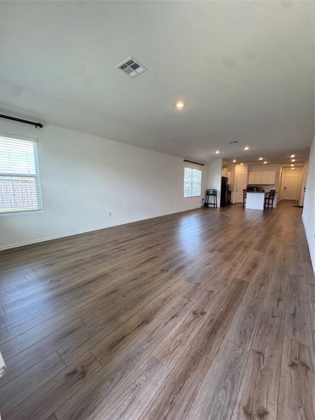 An open floorplan seamlessly connects the living area to the kitchen, bathed in ample light.