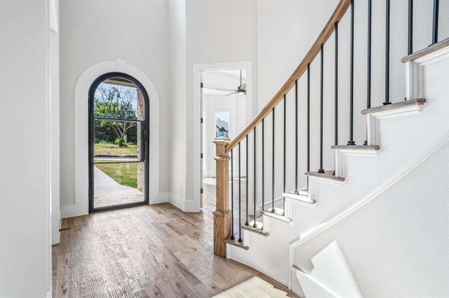 Foyer with a towering ceiling, light hardwood / wood-style flooring, and ceiling fan