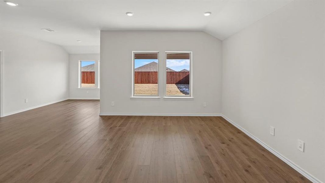 Spacious room with wood-finish flooring, recessed lighting, and light gray walls
